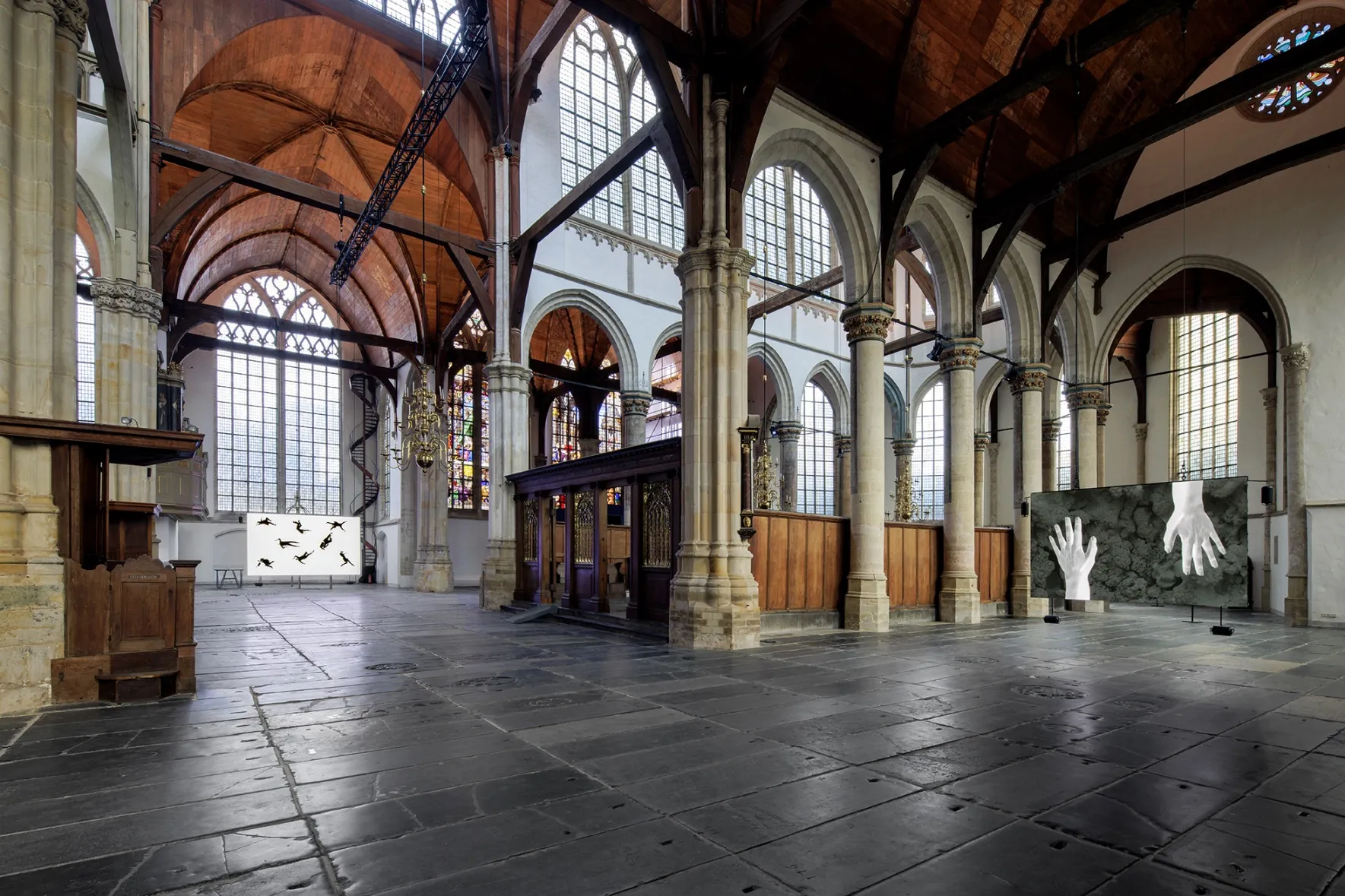 Two screens hanging in the space of the Oude Kerk