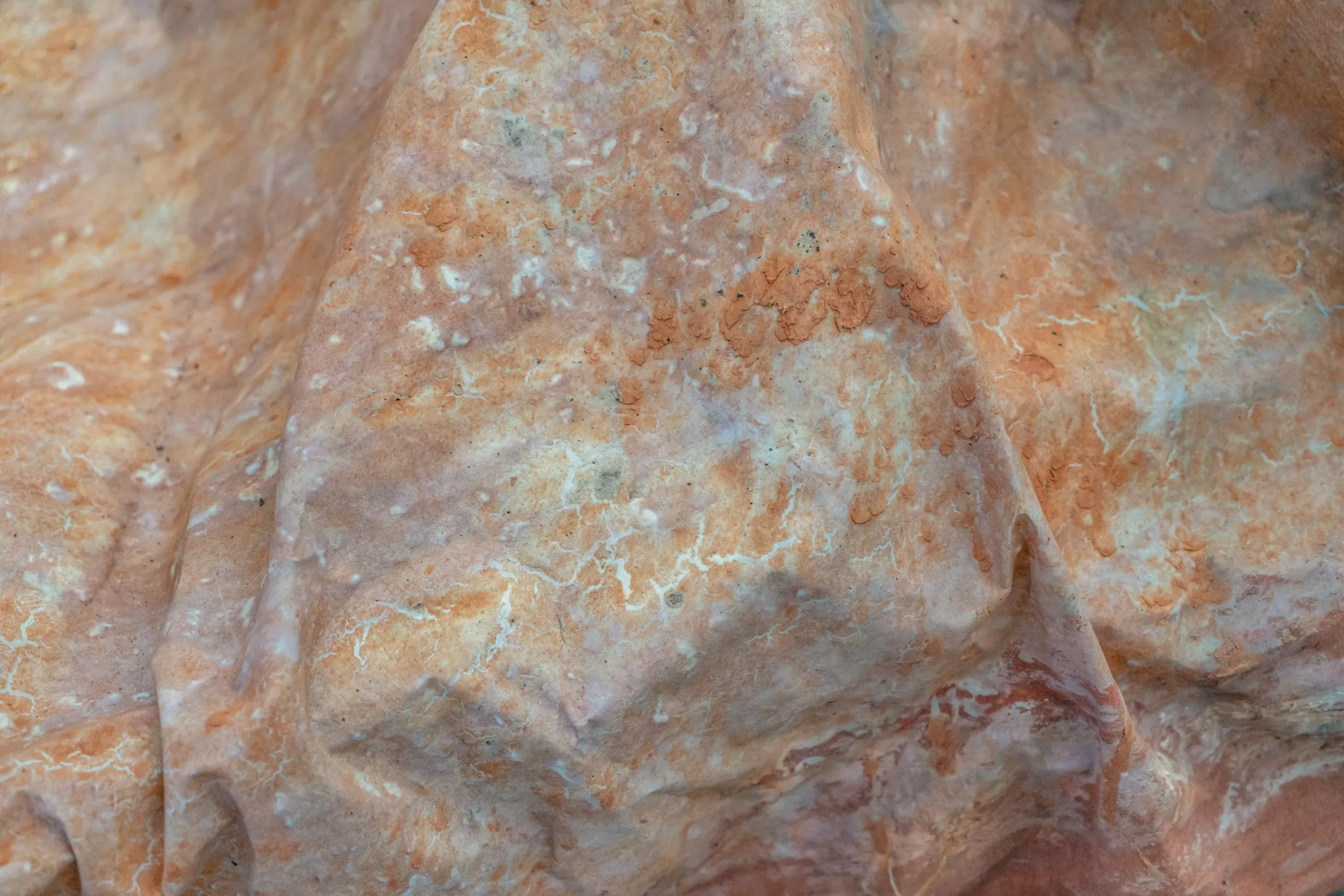 Close-up van een wiebelig doek met gedroogde en geharde oranje modderklei.